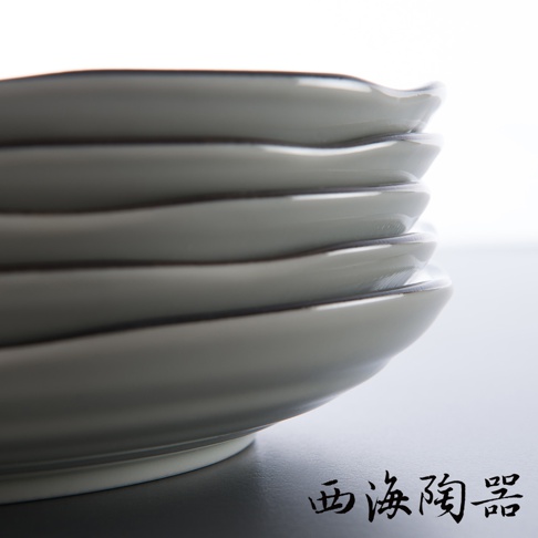 堆疊的日本美濃燒淺灰色圓盤，盤面有細緻的波浪紋理，邊緣帶有深色線條。