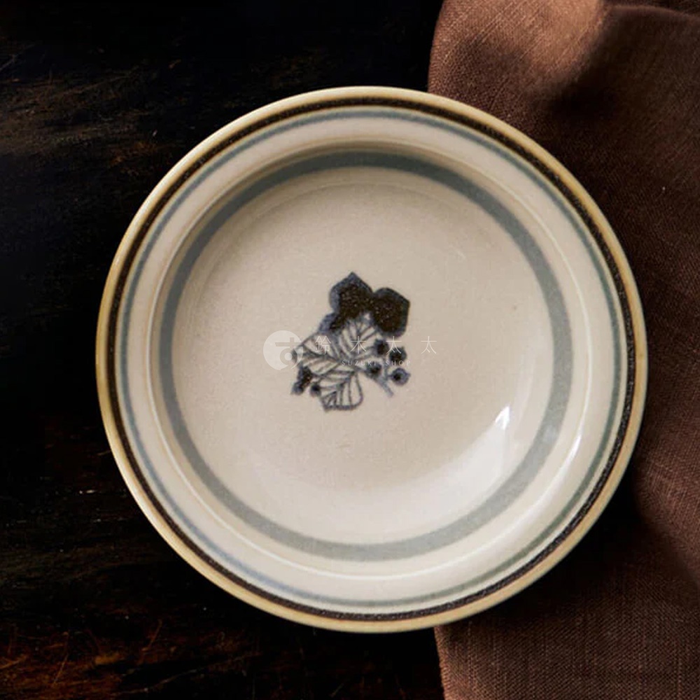 Anyware 美濃燒葉紋復古溫潤小碗，米白色陶瓷碗身，內側有藍色葉紋裝飾，碗緣有藍色與米色條紋，搭配褐色布料背景。