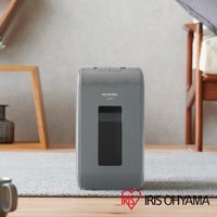 IRIS OHYAMA 灰色極細保密碎紙機，設有透明視窗，擺放在地毯和木質地板上，背景為家居裝飾。