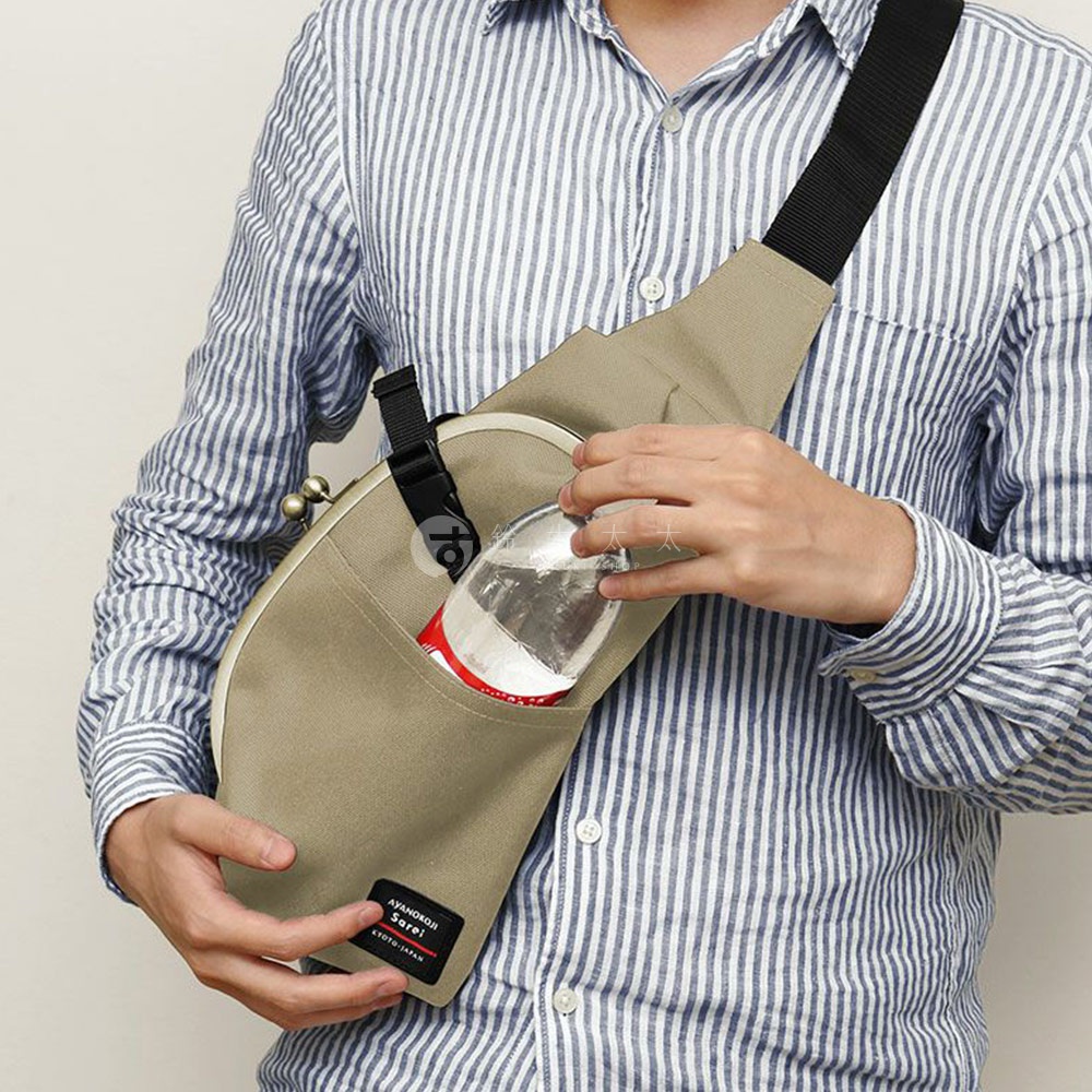 一個穿著藍白條紋襯衫的人，斜肩背著一個卡其色口金包，包裡裝著一瓶水。