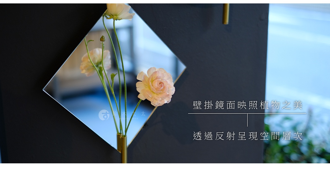 菱形鏡面壁掛花器，搭配粉色牡丹花與綠色枝葉，鏡面反射出藍色與綠色背景。
