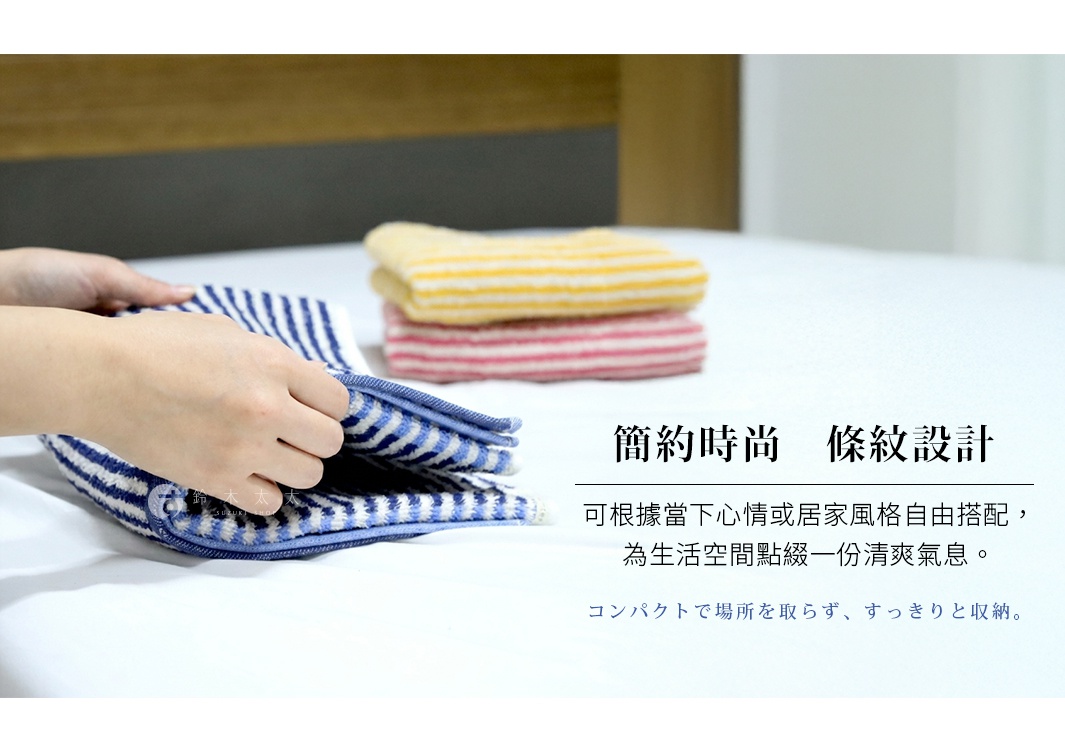 這張照片展示了今治有機棉麻雙色條紋迷你浴巾，畫面中有一雙手正在折疊藍白條紋的浴巾，背景處疊放著另外兩條黃白與粉白條紋的浴巾，整體呈現簡約時尚的居家風格，圖片並標註了適合隨心情與居家空間自由搭配的設計特色。