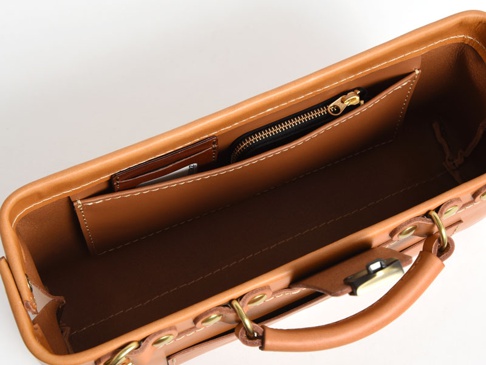 職人手作皮革橫長形杜勒斯單肩包 (CW-4)，展示包內部，包含一個拉鍊小零錢包，一個卡片夾層，以及皮革內襯，整體為棕褐色皮革材質，縫線清晰。