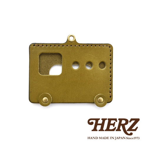 日本HERZ手工皮革製作的巴士造型卡夾，黃綠色皮革，有車窗和車輪細節，頂部有掛環，下方有品牌標誌「HERZ HAND MADE IN JAPAN Since1973」。