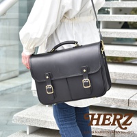 黑色皮革製成的手提單肩包，配有金色搭扣和可調節肩帶，展現精緻的縫線細節。