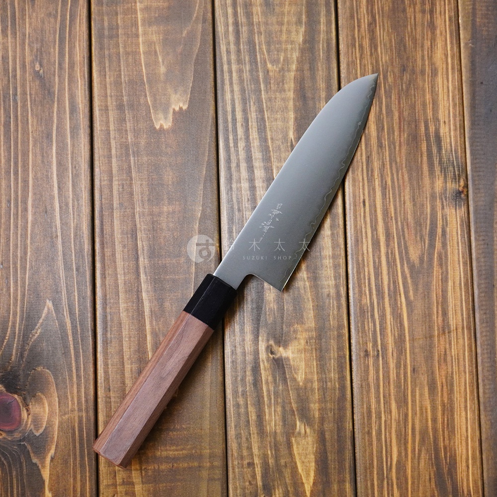 景清 Chromax 鋼三德刀，18cm 刀刃，帶有胡桃木手柄，放在木紋背景上。