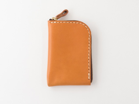 棕色皮革迷你錢包，帶有拉鍊和皮革拉環，縫線整齊，邊緣圓潤。