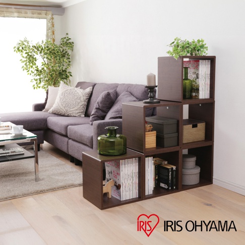 深棕色圓角無門組合收納櫃，呈現階梯式堆疊，櫃內擺放書籍、裝飾盒及綠色玻璃花瓶。