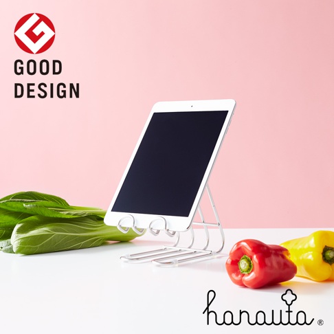 銀色不鏽鋼萬用支架，可放置平板電腦，支架下方有兩條橫桿，前方擺放著青江菜、紅甜椒和黃甜椒。