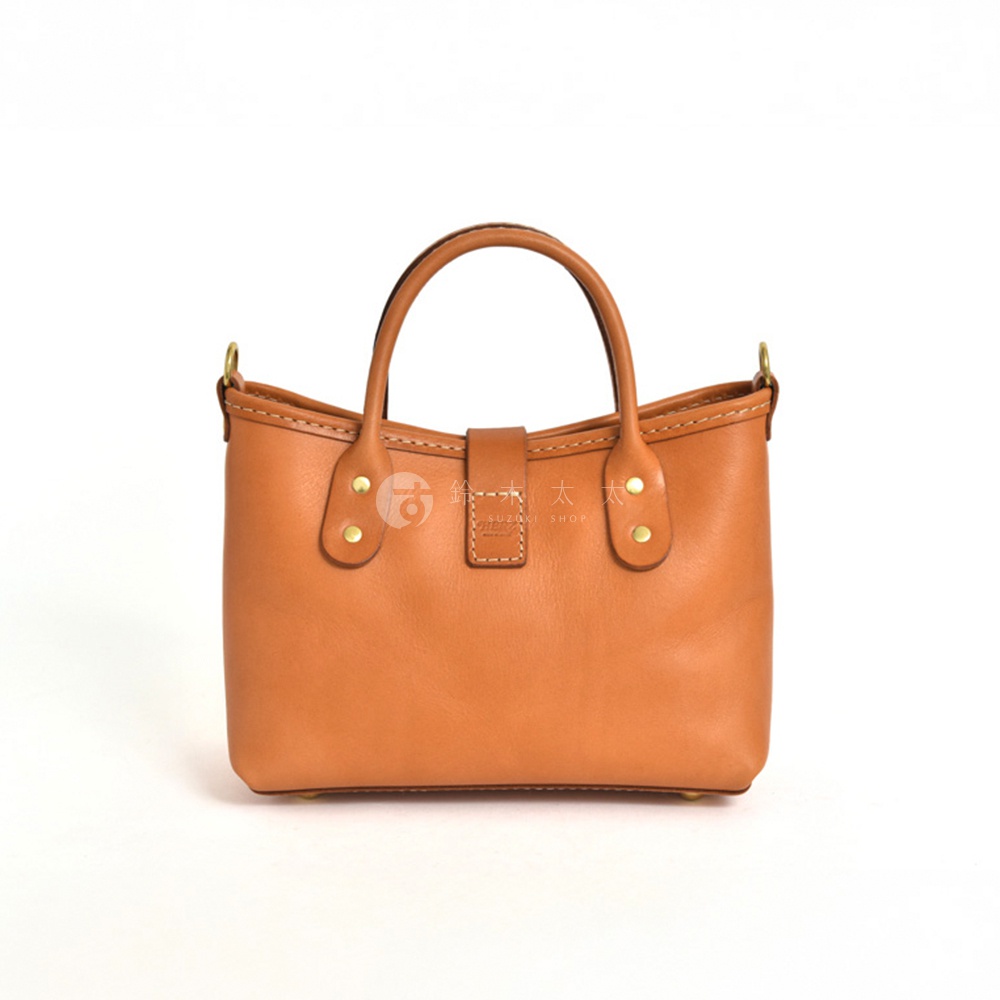 職人手作皮革迷你托特包，呈現溫潤的棕褐色，包身結構紮實，配有提把及金屬釦環，整體風格簡約大方。