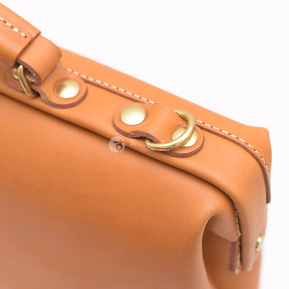 職人手作皮革軟式杜勒斯包BJ-68，採用原色皮革，搭配黃銅色五金扣環與铆釘，車縫線清晰，展現精緻工藝。