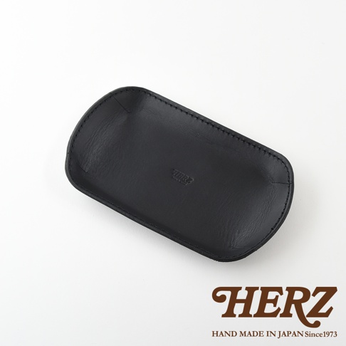 職人手作黑色皮革小物收納盤，皮質柔軟，邊緣縫線整齊，中央壓印有品牌Logo。