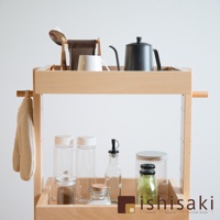 淺木色木製收納推車，頂層擺放著咖啡壺、馬克杯、餐具，側邊掛有淺褐色布巾；下層則有各式玻璃罐、瓶裝調味料。