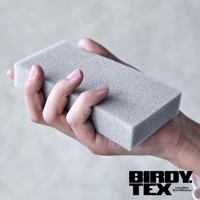 一隻手拿著灰色的長方形海綿刷，海綿材質具有細小的顆粒紋理。