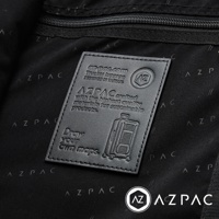AZPAC 黑色皮革標籤，印有品牌標誌、Trucker 3.0 行李箱、尺寸、設計於台灣、高質量永續材料、以及Draw your own maps的標語，背景為深色織物，上面有AZPAC的暗紋。
