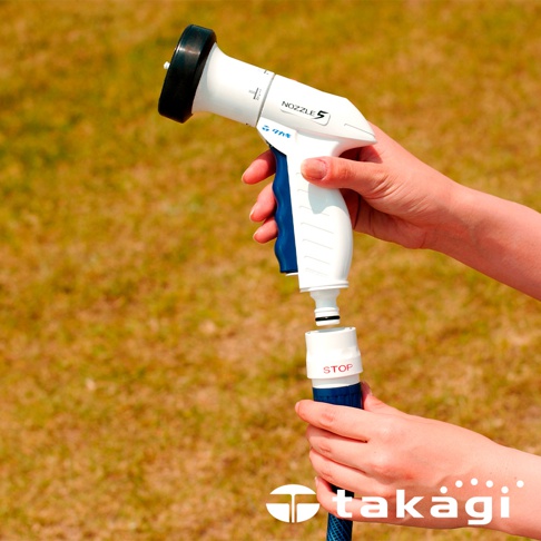 白色與藍色的灑水槍，帶有黑色噴嘴，下方連接白色轉接頭，與藍色水管的白色「STOP」接頭組裝。