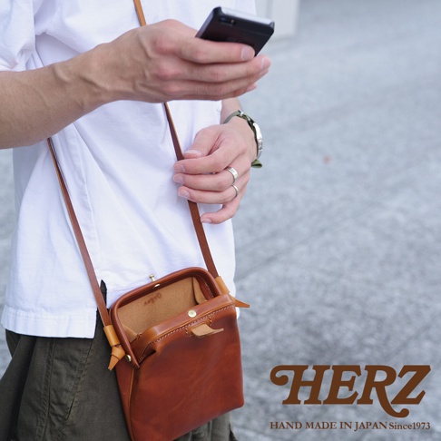 職人手作皮革Organ迷你杜勒斯側背包，採用天然皮革製成，呈現溫潤的焦糖棕色。包款設計簡約，搭配金屬釦環，可斜背或側肩背，展現俐落風格。