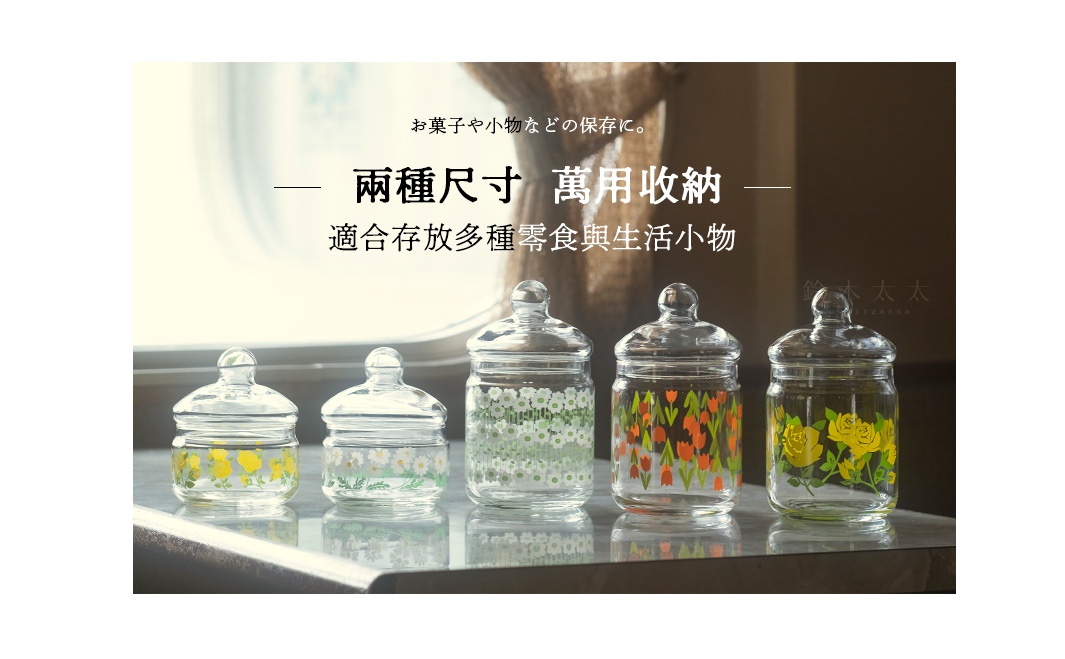 五個透明玻璃儲物罐，帶有蓋子，其中四個裝飾有不同顏色和圖案的花卉（黃玫瑰、雛菊、鬱金香），底部有細微的紋理。