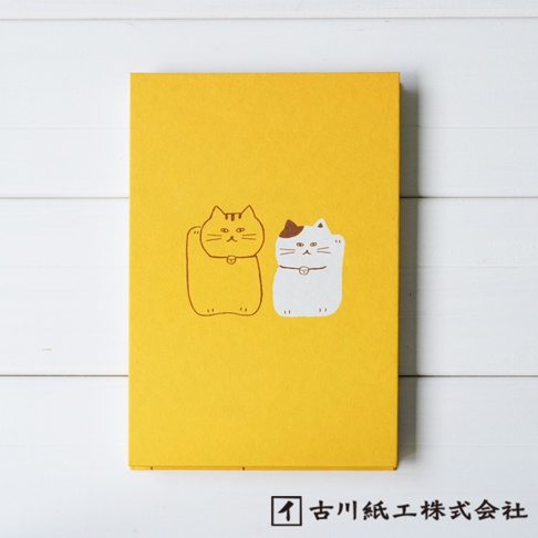 黃色和紙御朱印帳，封面有兩隻招福貓圖案，一隻為棕色線條勾勒，另一隻為白色，頭部有棕色斑紋，兩貓皆舉起右手。