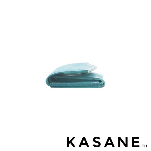 北海道KASANE 職人手作義大利Margot皮革迷你雙折短夾，展現迷人的青綠色皮革，以側面視角呈現精緻的摺疊設計。