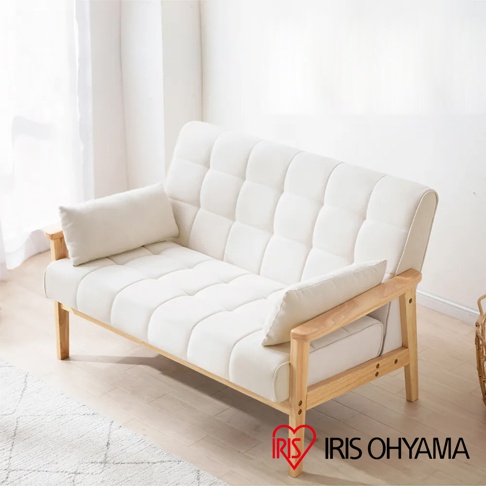 實木雙人布沙發，米白色，布面帶有方形格紋縫線，搭配實木框架與扶手，附有兩個小抱枕。