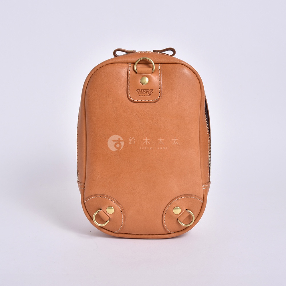 日本HERZ職人手作皮革立體運動斜背包，品牌標誌印在包包上方，下方有SUZUKI SHOP字樣。