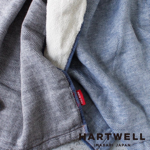 今治復古丹寧風雙織柔感毛巾，藍色牛仔布紋理，內層為白色毛巾材質，織紋清晰，帶有紅色「DENIM STYLE」布標。