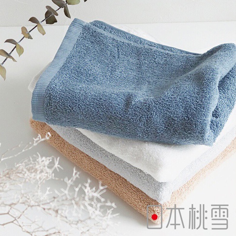 堆疊的飯店方巾，頂部為藍色，中間為白色，底部為淺褐色。方巾質地柔軟，邊緣有條紋裝飾。