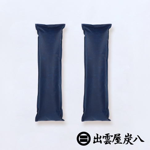 兩根深藍色長條形調濕木炭包，材質為無紡布，呈直立擺放，背景為白色。