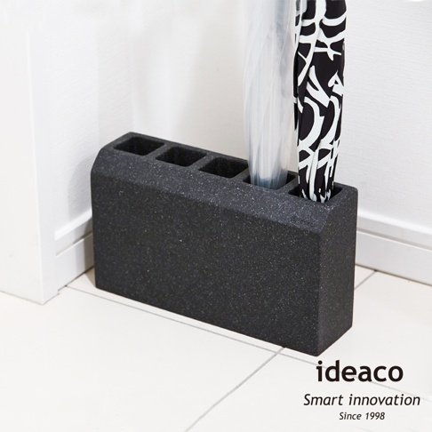 深灰色砂岩材質的五孔傘架，帶有圓潤的邊緣，可收納雨傘。