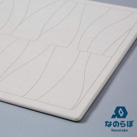UB珪藻土瞬間吸水地墊+鞋靴除濕墊組合，近拍白色地墊的局部，上面有曲線紋路，右下角有藍色菱形標誌與日文「な の ら ぼ」及英文「NanoLabo」字樣