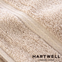 近拍的淺米色浴巾，材質為柔軟的棉，織紋清晰可見，呈現細緻的絨毛感。