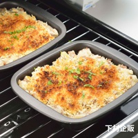 兩個深灰色、帶有烤至金黃色酥脆頂層的迷你方形烤盤，烤盤內盛有似乎是馬鈴薯泥與肉末混合的焗烤料理，並撒上切碎的綠色香料。