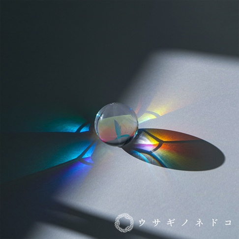 透明玻璃稜鏡球，在光線折射下投射出彩虹般的光斑。