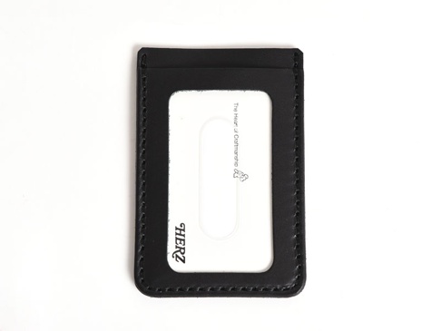 黑色職人手作皮革直式票券收納夾，帶有清晰的縫線和一個透明的票卡夾層，夾層內有「HERZ」品牌標誌與「The Heart of Craftsmanship」字樣。