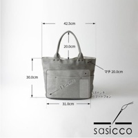 一款淺灰色三河木綿刺子織大開口托特包，帶有兩個皮革提把，正面有兩個外部口袋，標有 13 吋筆記型電腦和智慧型手機的尺寸標示，以及整體包款的尺寸標示。