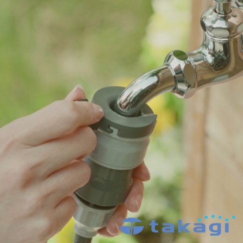 雙手正將灰色與淺灰色塑膠製成的快速接頭連接到閃亮的鍍鉻水龍頭。