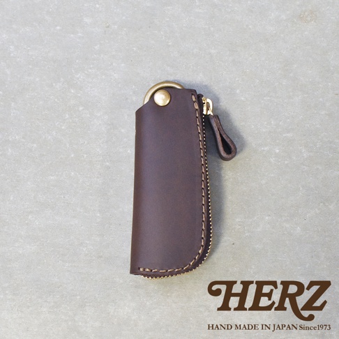 職人手作的深棕色皮革拉鍊鑰匙包，配有黃銅色鑰匙圈和拉鍊，以及皮革拉環。