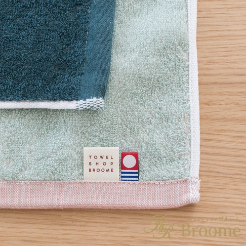 今治KAKUTERU純棉毛巾，採用撞色設計，包含深藍、淺綠及粉色邊飾。毛巾質感蓬鬆柔軟，帶有織標。