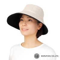 一位女性戴著一頂淺米色、寬緣遮陽帽，帽檐內側為黑色。帽子頂部材質有細緻的紋理。