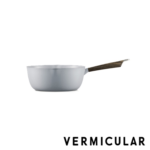 這是一款由 Vermicular 出品的淺灰色琺瑯鑄鐵雪平鍋，鍋身呈現圓潤的弧形線條，搭配一個質感極佳的深色木質長手柄，整體設計簡約且具備高質感，呈現出精緻的廚房料理用具形象。