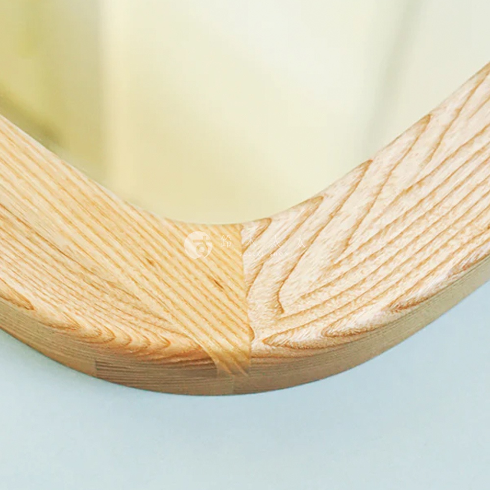 圓角木框萬用壁掛鏡，木紋清晰，淺木色調，鏡面反射淡黃色背景。