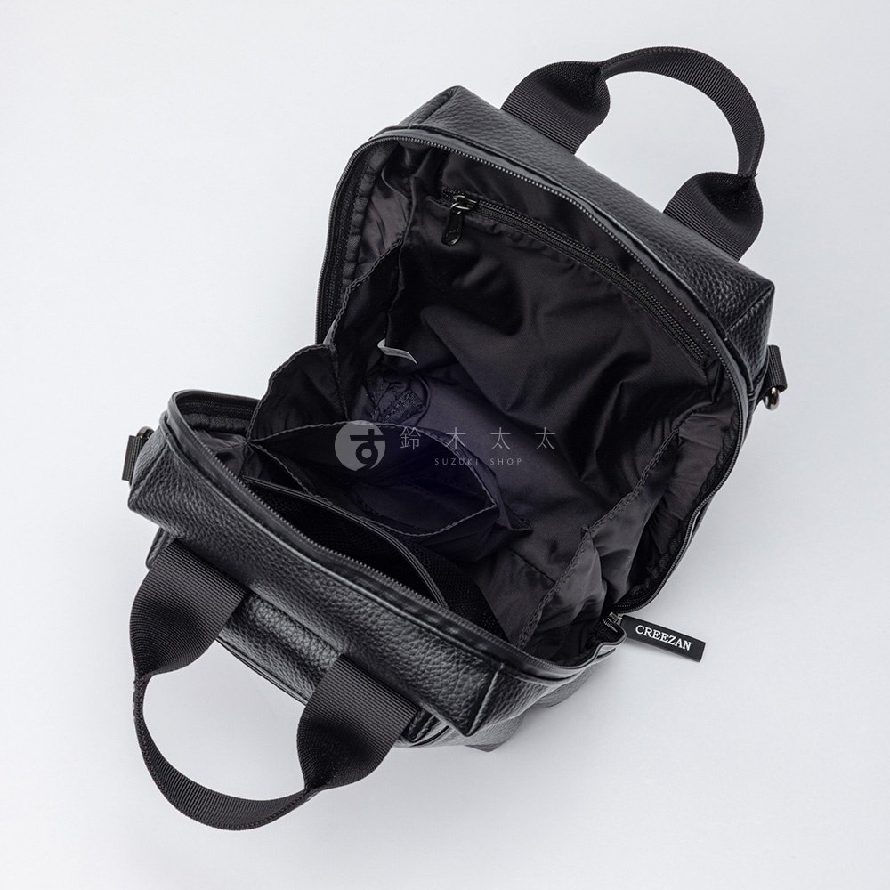 黑色方形側背包，仿皮革材質，主隔層內有網袋和拉鍊口袋，前袋有置物隔層，配有雙提把和可調式背帶。