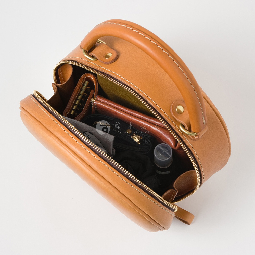 日本HERZ職人手作皮革兩用圓形包，棕色皮革，內部展示了錢包、鑰匙圈、小瓶裝物品等。