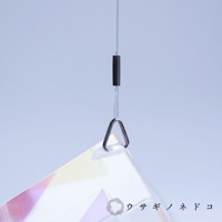 透明稜鏡立方塊吊飾，透過金屬環懸掛，底部可見部分彩虹色光澤，背景為淺藍色。