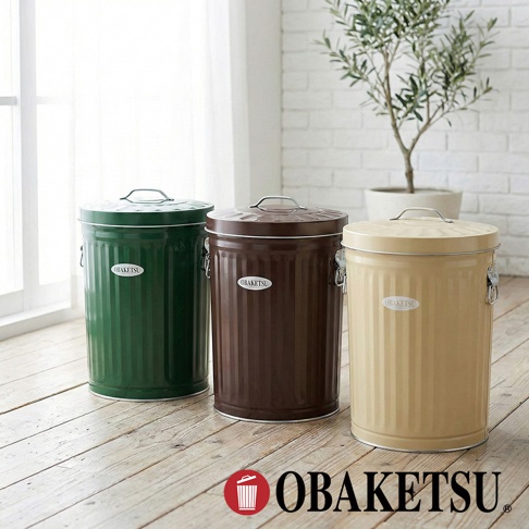 OBAKETSU 品牌經典款式垃圾桶，有綠色、咖啡色和米黃色三種顏色，擺放在木質地板上，背景有窗戶和綠植。