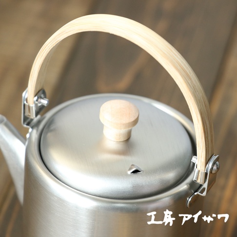 霧面不鏽鋼直筒茶壺，配有木質提把及壺蓋頂珠，壺身為銀色金屬質感，壺嘴帶有小巧的散熱孔。