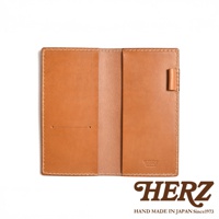 職人手作皮革輕便記事本書套，淺棕色，展開狀態，左側有兩個小孔，右側有筆套，內裡及邊緣皆有車縫線，右側內嵌品牌燙金標誌。