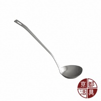 一只銀色不鏽鋼萬用料理勺，勺柄細長並帶有掛孔，勺頭呈圓弧狀，在右下角有一個圓形紅底白字的品牌標誌。