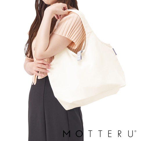 一位女士手提一個米白色摺疊保冷可拆托特袋，袋身材質為帆布。